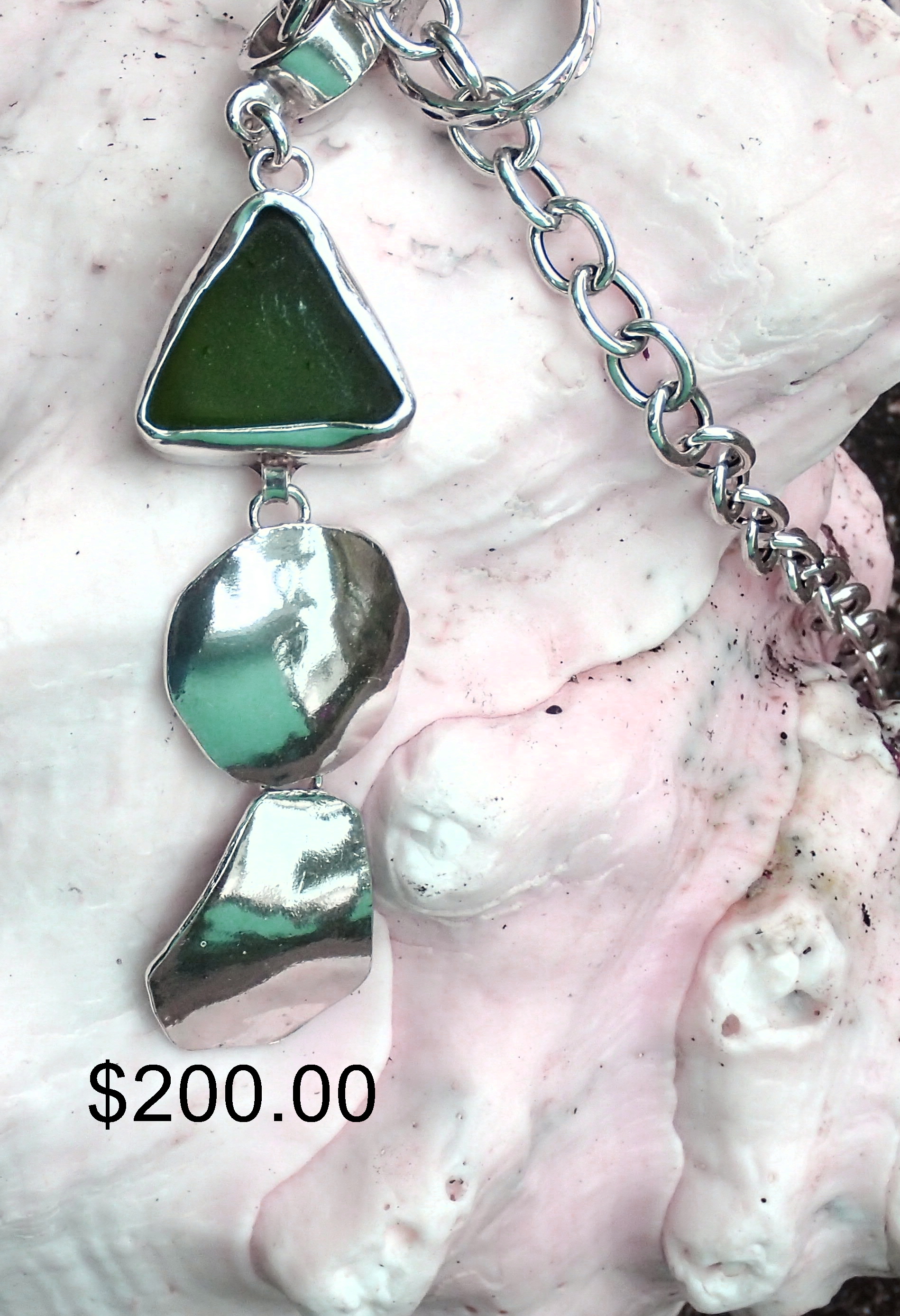 Chunky triangle antique green seaglass forms the head of a fish with fine silver finish.